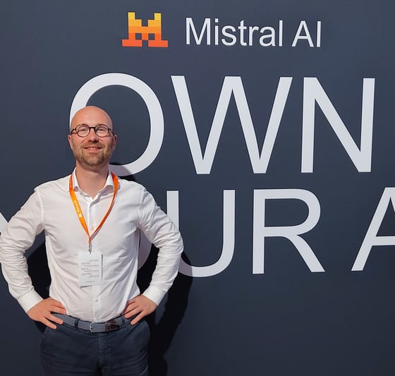 Christian Philippon, dirigeant de Melorio, devant le mur d'un événement Mistral AI portant la mention « own your AI »